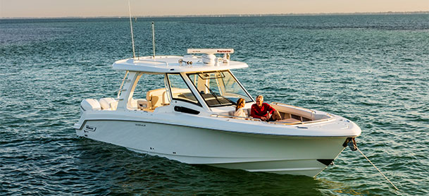 Boston Whaler 350 Realm anchored in water with couple on it