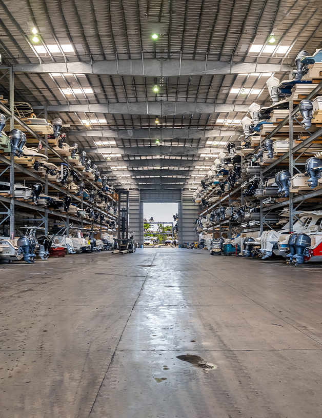 The inside of a boat storage warehouse with many boats on risers in Pensacola.