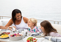 women and child eating on a boat