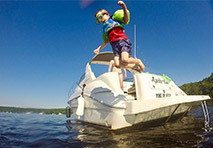 boy jumping off boat into water