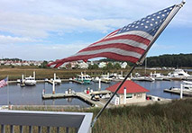 american flag waving with water in background