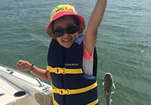 a young girl holding a fish