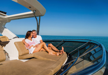 couple in each others arms lounging on deck chairs of yacht