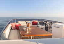 drinks sitting atop high quality wooden table surrounded by leather seating on pontoon
