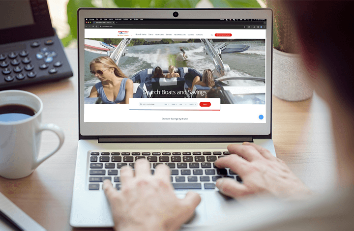 hands at a laptop with marinemaxcom on the screen