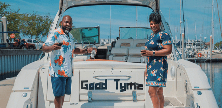 man and woman smiling next to their boat name good tyme