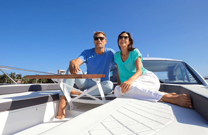 couple sitting on the bow of a cruisers yachts