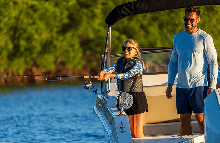 girl fishing with her dad on a boat