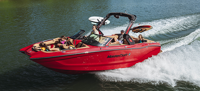 A red Mastercraft with wakeboarding equipment races across the water