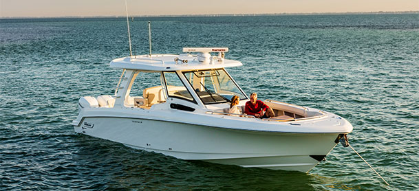 Boston Whaler 350 Realm anchored in water with couple on it