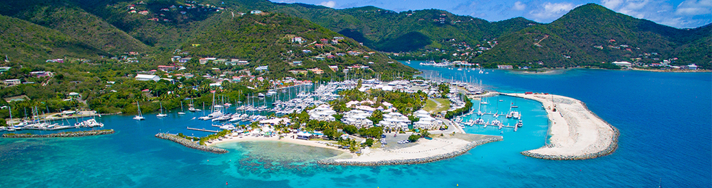 MarineMax Vacations base in tortola. Buildings on an island surrounded by white sandy beach and bright blue waters. 