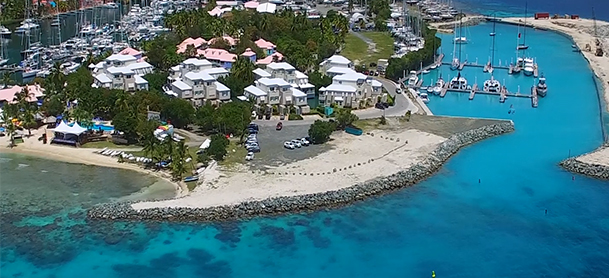 MarineMax Vacations base in tortola. Buildings on an island surrounded by white sandy beach and bright blue waters. 