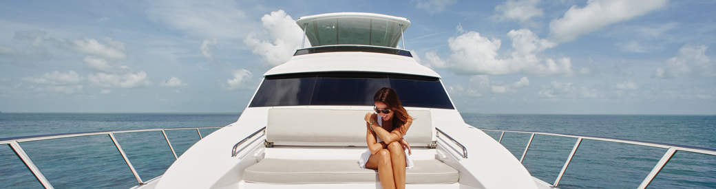 Woman lounges on the front of beautiful yacht