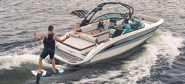 a wakeboarder behind a sport boat