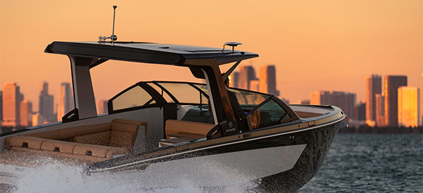 Aviara 32 driving on water creating wake with city skyline in the distance