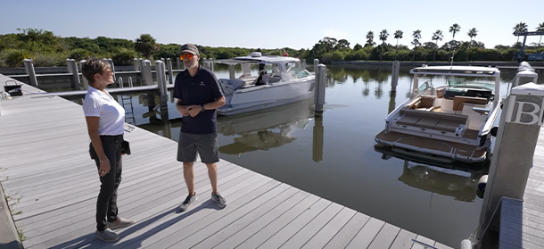 two people standing on a dock with Aviara on the water