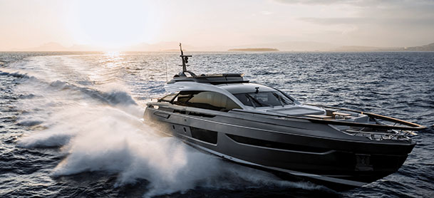 S10 speeds across the ocean at sunset, creating a dynamic spray of water against the calm waves.