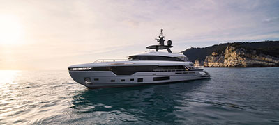 Azimut Grande Trideck sitting in water with cliff in background