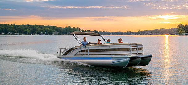 Group of people on R Series Bennington pontoon with sunset in the background