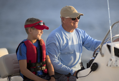 Grandfather fishing with grandson on a boat 