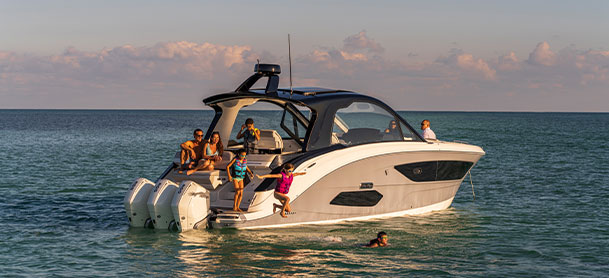 family out on a boat with kids jumping into water