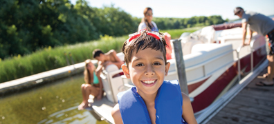 child smiling in front of pontoon