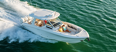 A white Boston Whaler boat sails across the water