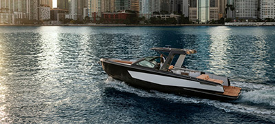 An Aviara boat cruising in the water with a city skyline in the background