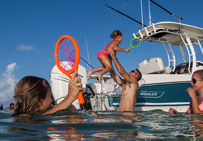 Family in water with Boston Whaler 230 Outrage