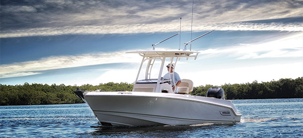 Man driving Boston Whaler 230 Outrage in calm water