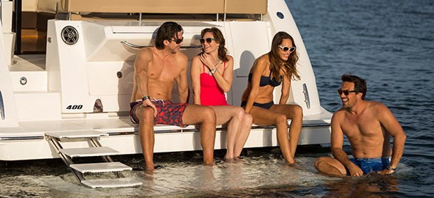 Sea Ray Fly 400 with two couples sitting on swim platform