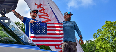Guys holding a flag on the lake