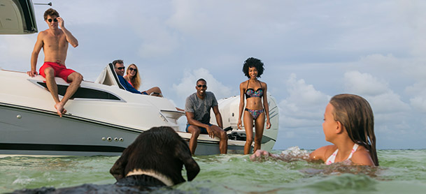 family on boat and in the water
