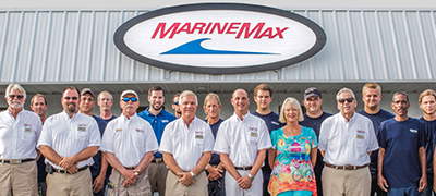 Team of MarineMax Employees standing in front of a store with a large sign over head