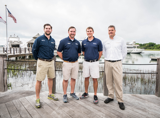 Marinemax employees stand on dock in front of boats