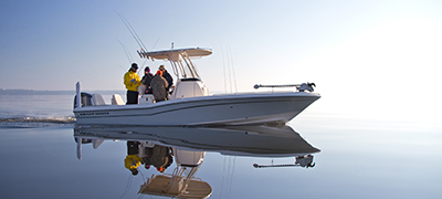 fishing boat with people on board running slowly across glassy open water