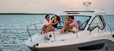 couples sitting on the bow of a boat at sunset