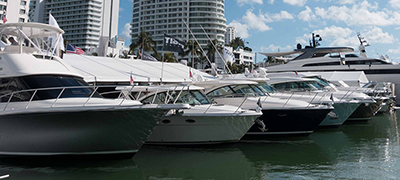 boats lined up along a dock with skyscrapers in the background