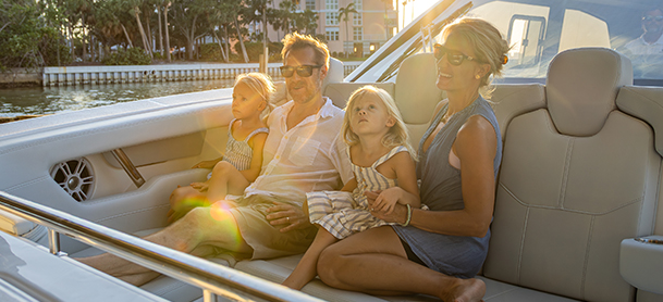 A family of four enjoys a sunny boat ride.