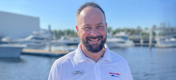 Jody Mitchell, the new MarineMax Jacksonville General Manager, stands in front of a marina.