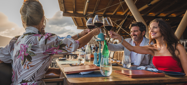 group of people clanking glasses together at table