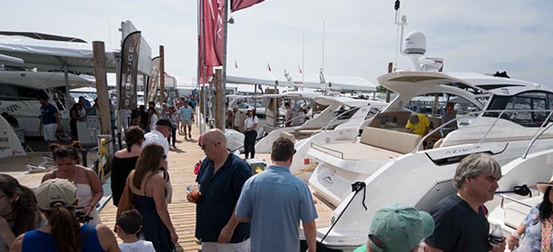 people walking along the dock at an outdoor boat show