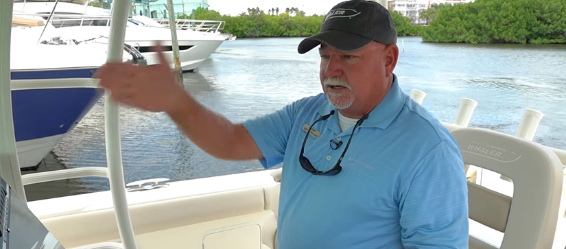 male captain with arm pointing at the helm