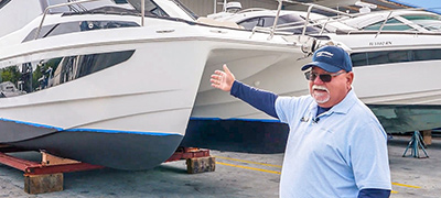 Captain Keith pointing to an Aquila Catamaran