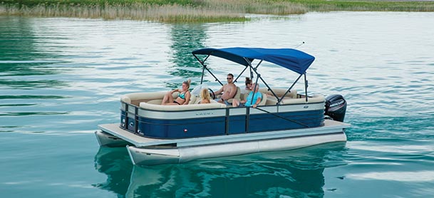 A family on a Crest pontoon as it cruises through clear blue water