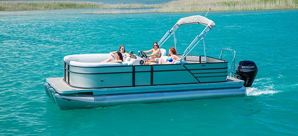 A family on a Crest pontoon as it cruises through clear blue water
