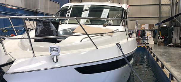 A white Galeon yacht resting in water in a testing tank in a factory