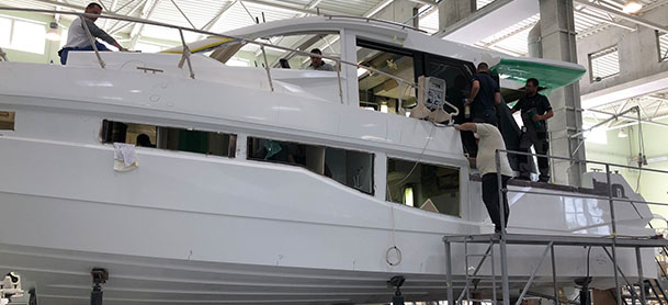 Four men working on a yacht in a factory