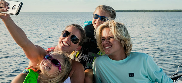 A family smiling for a photo on a boat