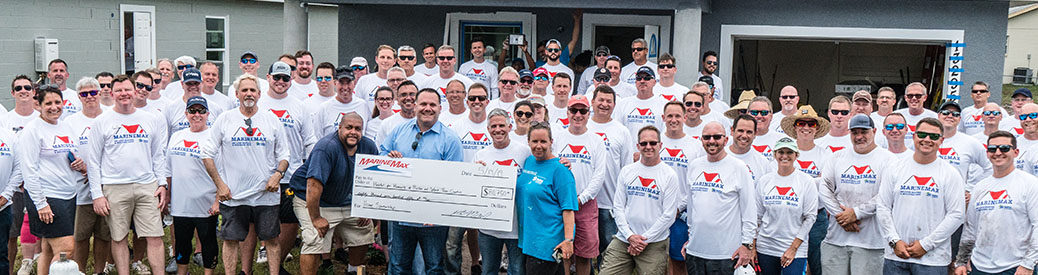 MarineMax team members holding a large check